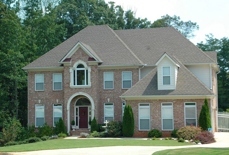 A large brick house with trees in the background.